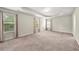 Large bedroom featuring neutral carpet, multiple windows, and tray ceilings at 2680 Lower Village Dr, Ellenwood, GA 30294