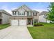 Charming two-story home with a brick facade, two-car garage, and a well-manicured front lawn at 2680 Lower Village Dr, Ellenwood, GA 30294