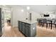 Open kitchen with island, granite countertops, stainless steel appliances, and adjacent dining and living areas at 2680 Lower Village Dr, Ellenwood, GA 30294
