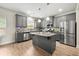 Modern kitchen with gray cabinets, stainless steel appliances, granite countertops, and a center island at 2680 Lower Village Dr, Ellenwood, GA 30294