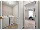 Bright laundry room featuring a washer, dryer, and wire shelving for storage at 2680 Lower Village Dr, Ellenwood, GA 30294