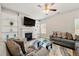 Cozy living room featuring a fireplace, built-in shelves, ceiling fan, and large window at 2680 Lower Village Dr, Ellenwood, GA 30294