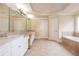 Luxurious bathroom featuring a double vanity, soaking tub, and decorative tile flooring at 2688 Hidden Falls Ne Dr, Buford, GA 30519