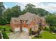 Aerial view of a brick two-story home showcasing its roof and well-manicured lawn and driveway at 2688 Hidden Falls Ne Dr, Buford, GA 30519