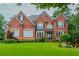 Beautiful two-story brick home with lush lawn, landscaping, and symmetrical design at 2688 Hidden Falls Ne Dr, Buford, GA 30519