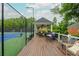 Enjoy outdoor relaxation on this covered deck beside a tennis court, perfect for entertaining or a relaxing afternoon at 2688 Hidden Falls Ne Dr, Buford, GA 30519