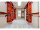 Walk-in closet featuring custom wooden shelving with hanging racks for storing clothes and accessories at 2688 Hidden Falls Ne Dr, Buford, GA 30519