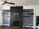 Inviting living room with a black tile fireplace, floating shelves, and modern ceiling fan at 3208 Sonnet Se Walk, Atlanta, GA 30339