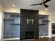 Inviting living room with a black tile fireplace, floating shelves, and modern ceiling fan at 3208 Sonnet Se Walk, Atlanta, GA 30339