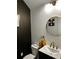Contemporary powder room with a round mirror, stylish fixtures, and dark accent wall at 3208 Sonnet Se Walk, Atlanta, GA 30339