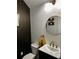 Contemporary powder room with a round mirror, stylish fixtures, and dark accent wall at 3208 Sonnet Se Walk, Atlanta, GA 30339