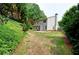 Expansive backyard featuring a gray two-story home, lush greenery, and a mature tree line at 3954 Rhyne Se Way, Smyrna, GA 30082