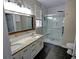 Modern bathroom with double vanity, granite countertop, and glass-enclosed shower with decorative tile at 3954 Rhyne Se Way, Smyrna, GA 30082