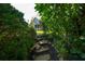 Stone pathway leading to a porch with columns framed by lush greenery at 5223 Willow Ridge Dr, Woodstock, GA 30188