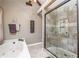 Bathroom featuring tub, shower with glass doors and neutral tile, and window at 5223 Willow Ridge Dr, Woodstock, GA 30188