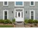 Elegant front entrance featuring a decorative white door flanked by sidelights and lush landscaping at 5223 Willow Ridge Dr, Woodstock, GA 30188