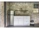 Outdoor kitchen with stainless steel mini fridge, storage cabinets, sink, and stone walls at 879 Wildwood Ne Rd, Atlanta, GA 30324