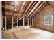 Unfinished attic space ready for renovation, featuring exposed rafters, wood boards, and a window for natural light at 879 Wildwood Ne Rd, Atlanta, GA 30324