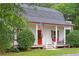 Charming cottage-style home with a front porch, an American flag, and lush landscaping at 121 Gosdin Rd, Palmetto, GA 30268