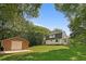 Exterior view of the home and detached garage, surrounded by green grass and trees at 121 Gosdin Rd, Palmetto, GA 30268