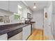 Galley kitchen featuring updated appliances, wood floors, and granite countertops at 121 Gosdin Rd, Palmetto, GA 30268