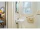 Cozy powder room featuring a pedestal sink, window, and neutral decor at 1821 N Rock Springs Ne Rd, Atlanta, GA 30324
