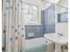 Bathroom features a blue and white tile bathtub and shower combination with a vintage-style sink at 1821 N Rock Springs Ne Rd, Atlanta, GA 30324