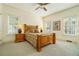 Comfortable bedroom featuring light walls, carpet, a ceiling fan, and large windows to bring in natural light at 1821 N Rock Springs Ne Rd, Atlanta, GA 30324