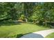 Large grassy front yard leading to a tree-covered house at 1821 N Rock Springs Ne Rd, Atlanta, GA 30324