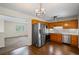 Open-concept kitchen with stainless steel appliances and wood cabinets flows into the living area with carpet at 208 Bruce Ct, Dallas, GA 30157