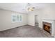 Comfortable living room featuring a stone fireplace, ceiling fan, and large window at 208 Bruce Ct, Dallas, GA 30157