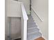 A stairway with carpeted steps and white railings, adjacent to a closed door at 208 Bruce Ct, Dallas, GA 30157