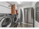 Laundry room features stainless steel washer, dryer, and refrigerator at 2136 Briarwood Ct, Snellville, GA 30078