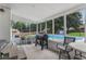 Screened porch with brick walls and outdoor seating overlooking a pool and backyard at 2136 Briarwood Ct, Snellville, GA 30078