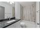 A modern bathroom boasts a gray granite vanity, sleek fixtures, and a tub-shower with wood-look tile surround at 103 Willow Wood Se Cir, Atlanta, GA 30317