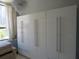 Bright bedroom with large window, crystal chandelier, and built-in wardrobes at 115 W Peachtree Nw Pl # 702, Atlanta, GA 30313