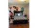 Bedroom with hardwood floors, black trim bed, and unique hand drawn custom cartoon wall art at 2510 Lakeshore Ne Dr, Conyers, GA 30012