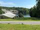Home overlooking a lake with an island and surrounded by trees and a chain link fence at 2510 Lakeshore Ne Dr, Conyers, GA 30012