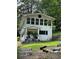 Two-story white home featuring large windows and a covered front porch with landscaping at 2510 Lakeshore Ne Dr, Conyers, GA 30012