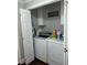 Well-equipped laundry room featuring modern washer and dryer with storage, shelving and wood flooring at 2510 Lakeshore Ne Dr, Conyers, GA 30012