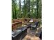 A wooden patio featuring outdoor seating surrounded by lush green trees at 2510 Lakeshore Ne Dr, Conyers, GA 30012