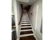 Bright staircase with wood treads, white risers, and decorative wall art leading to the upper level at 2510 Lakeshore Ne Dr, Conyers, GA 30012