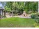 Landscaped backyard featuring a stone fireplace, manicured lawn, and a charming pergola, perfect for outdoor gatherings at 2544 Thompson Ne Rd, Brookhaven, GA 30319