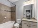 Bathroom featuring tiled tub and granite countertops, creating an aesthetically pleasing and functional space at 2544 Thompson Ne Rd, Brookhaven, GA 30319