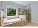 Luxurious bathroom features a soaking tub, glass shower and view of trees at 2544 Thompson Ne Rd, Brookhaven, GA 30319