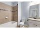Well-lit bathroom featuring a tub with tiled walls and granite countertops, offering a clean, modern design at 2544 Thompson Ne Rd, Brookhaven, GA 30319