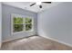 Neutral bedroom features a ceiling fan and a large window with an outside view at 2544 Thompson Ne Rd, Brookhaven, GA 30319