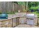 Elegant outdoor kitchen is equipped with stone counters, stainless steel appliances, and ample prep space at 2544 Thompson Ne Rd, Brookhaven, GA 30319