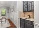 Charming wet bar area featuring dark cabinetry, mosaic tile backsplash, and granite countertop at 2544 Thompson Ne Rd, Brookhaven, GA 30319