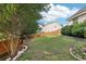 Large grassy backyard with a wooden fence and mature tree at 7033 Brecken Trce, Lithonia, GA 30058